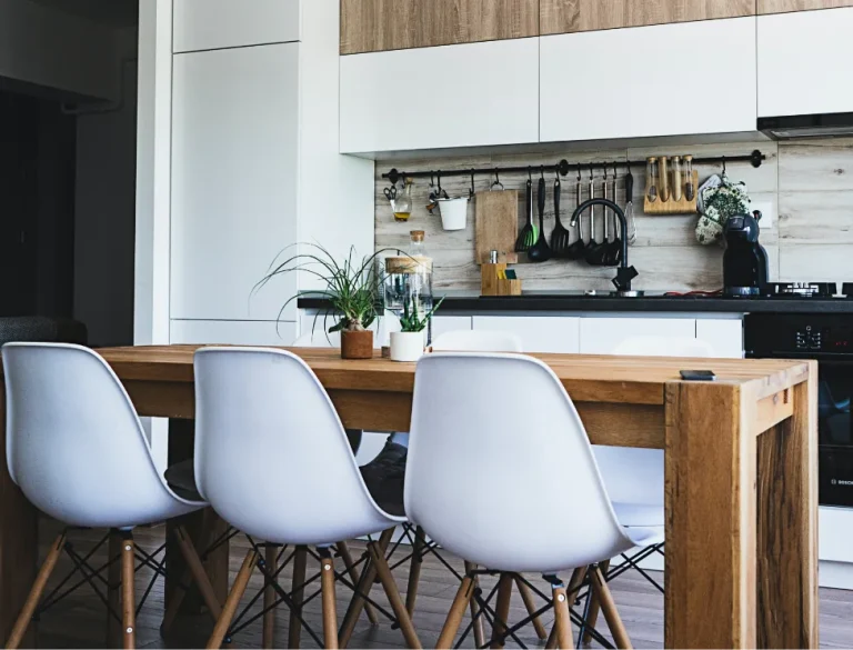 Cocina comedor con mesa de madera y sillas blancas