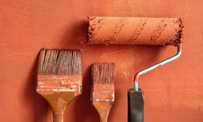 Brochas y rodillo con pintura naranja