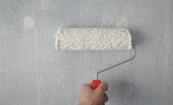 Rodillo aplicando pintura blanca en la pared